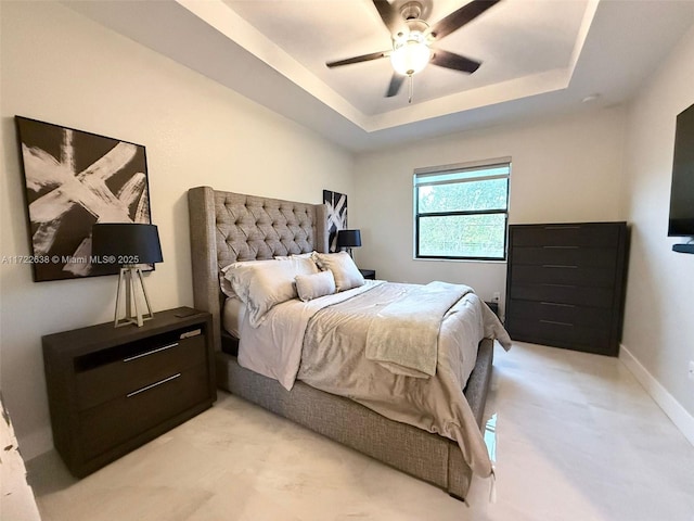 bedroom with ceiling fan and a tray ceiling