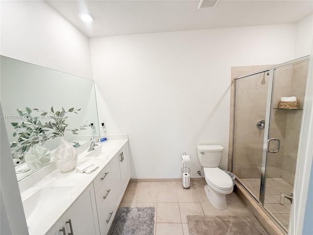 bathroom with a shower with shower door, toilet, vanity, and tile patterned flooring