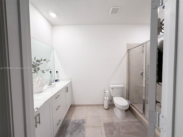 bathroom featuring tile patterned floors, vanity, toilet, and walk in shower