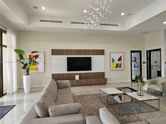 tiled living room featuring a raised ceiling and an inviting chandelier