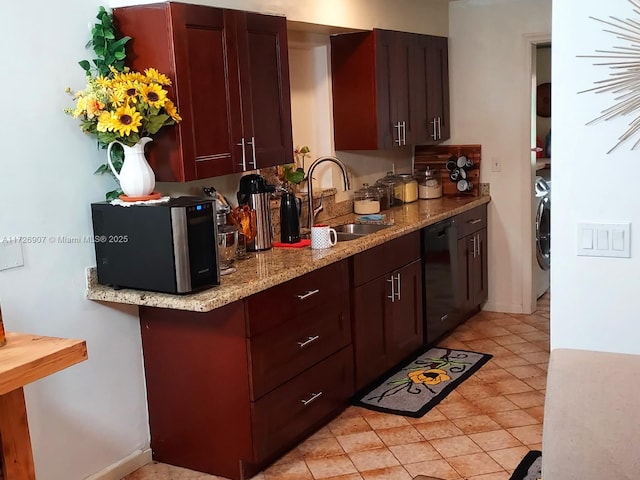 kitchen featuring washer / clothes dryer, sink, light tile patterned flooring, black dishwasher, and light stone counters