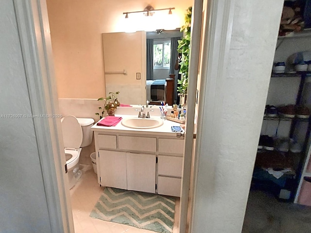 bathroom with toilet, vanity, and tile patterned floors