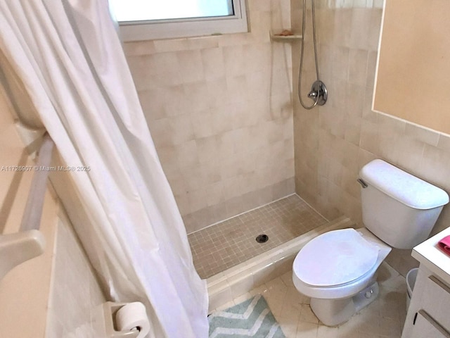 bathroom featuring tile patterned flooring, vanity, tile walls, toilet, and walk in shower