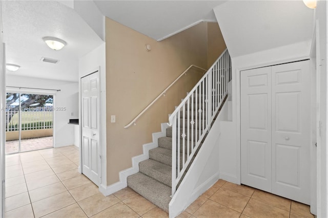 stairs featuring tile patterned flooring