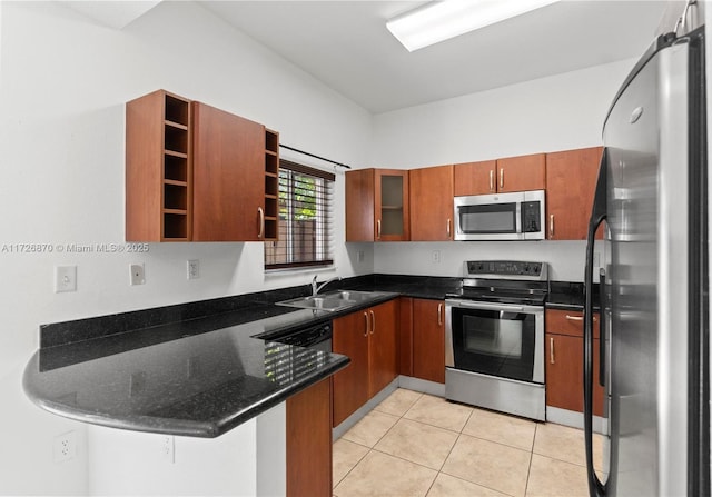 kitchen featuring stainless steel appliances, dark stone counters, sink, kitchen peninsula, and light tile patterned flooring