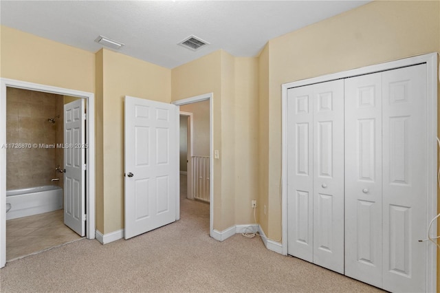 unfurnished bedroom with connected bathroom, a closet, and light colored carpet