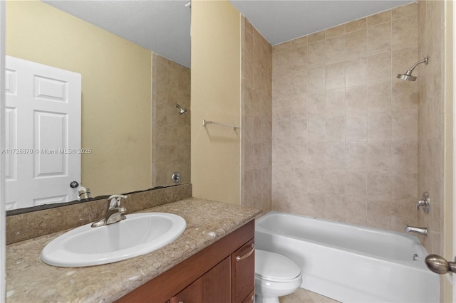 full bathroom featuring toilet, vanity, and tiled shower / bath