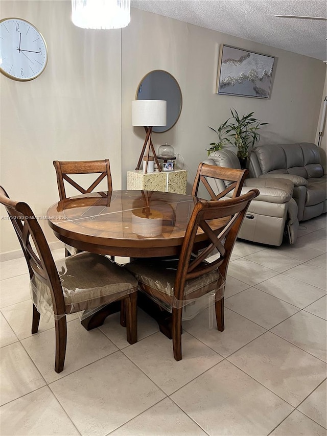 tiled dining area featuring a textured ceiling