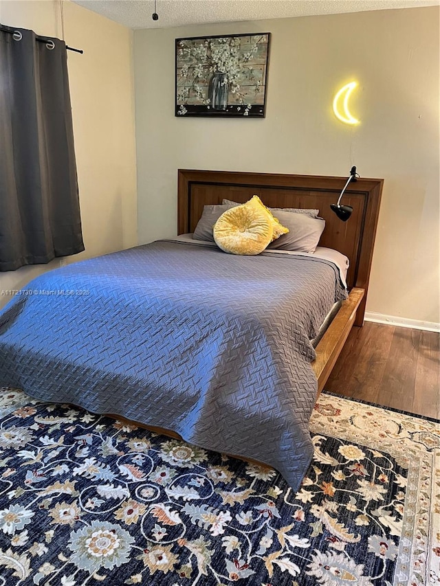 bedroom with hardwood / wood-style flooring and a textured ceiling