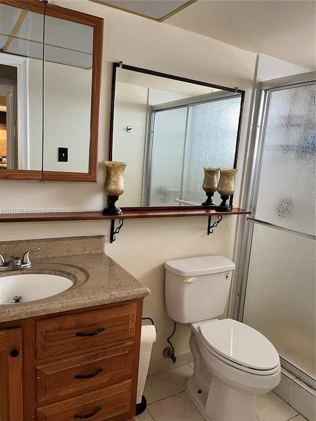 bathroom featuring toilet, tile patterned floors, walk in shower, and vanity