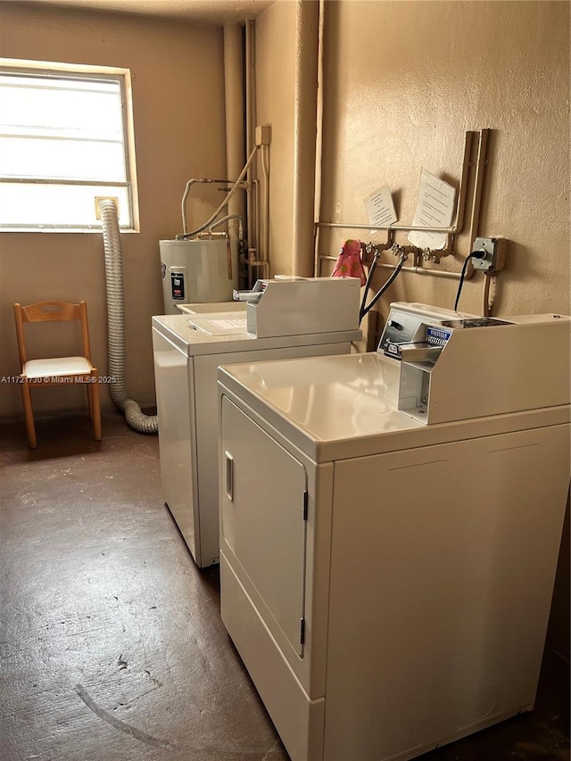 washroom with electric water heater and washer and clothes dryer