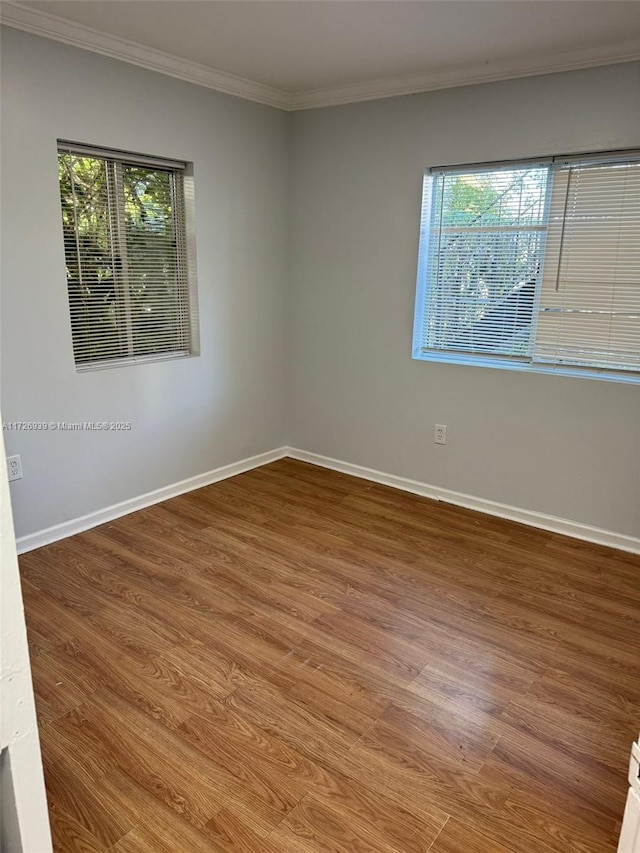 empty room with plenty of natural light, baseboards, and wood finished floors