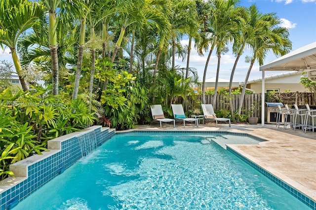 view of swimming pool with pool water feature and a patio