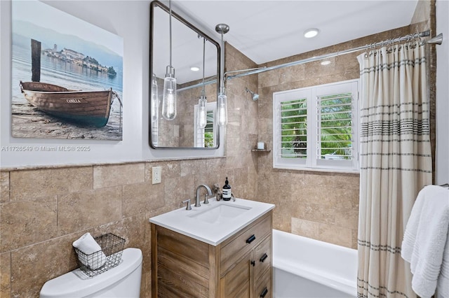 full bathroom with toilet, vanity, tile walls, and shower / bath combo with shower curtain