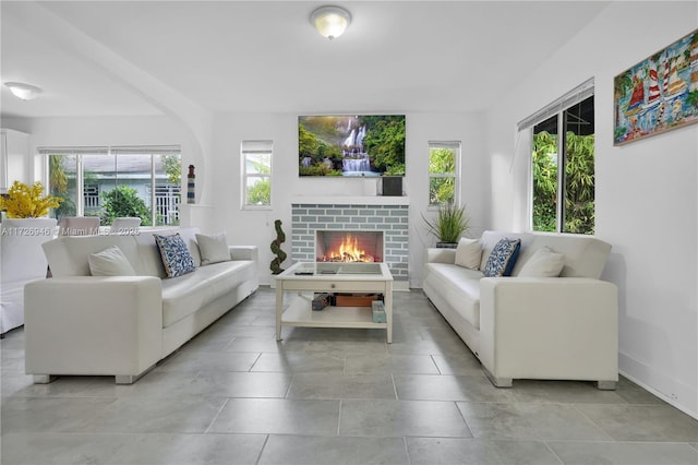 living room with a fireplace and plenty of natural light