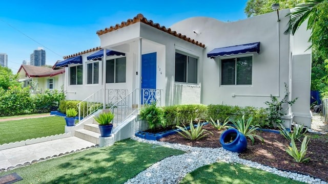 mediterranean / spanish-style home featuring a front yard