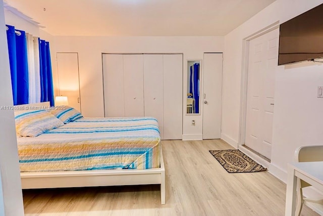 bedroom featuring two closets and hardwood / wood-style floors