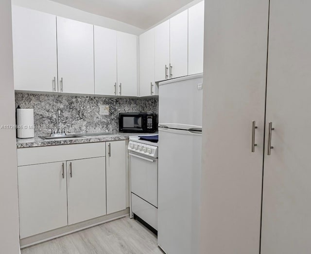 kitchen featuring tasteful backsplash, sink, white appliances, white cabinetry, and light hardwood / wood-style flooring