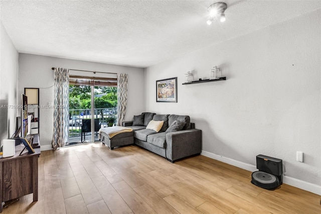 living room featuring a textured ceiling and light hardwood / wood-style floors