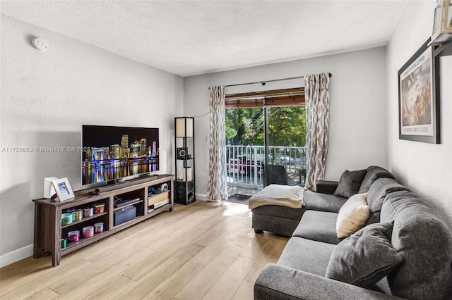 living room with light wood-type flooring and a textured ceiling