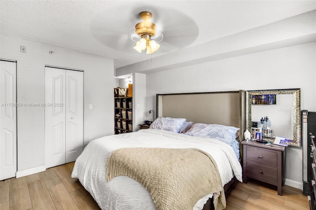 bedroom with a textured ceiling, ceiling fan, and light hardwood / wood-style flooring