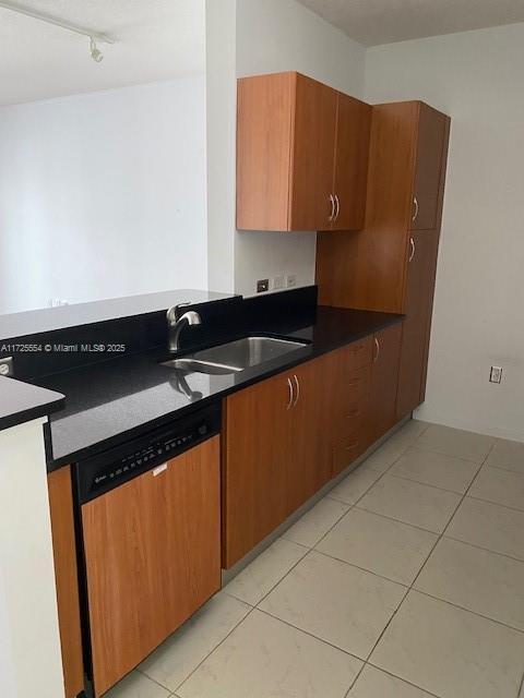 kitchen featuring light tile patterned flooring, paneled dishwasher, and sink