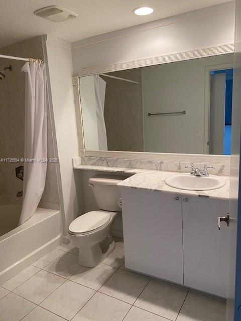 full bathroom with shower / bath combo with shower curtain, toilet, vanity, and tile patterned flooring