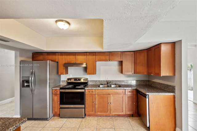 kitchen with light tile patterned flooring, stainless steel appliances, a textured ceiling, and sink