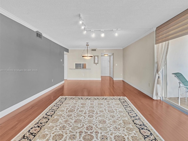 living room featuring a textured ceiling, track lighting, crown molding, and light hardwood / wood-style floors