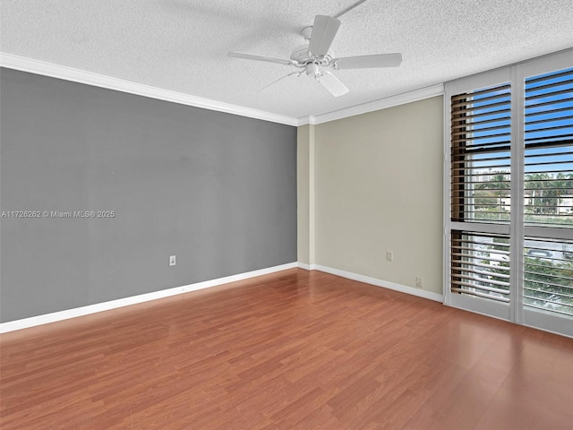 spare room featuring a textured ceiling, ceiling fan, crown molding, and hardwood / wood-style flooring