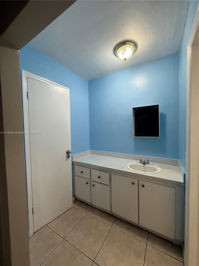 bathroom featuring a textured ceiling, vanity, and tile patterned flooring