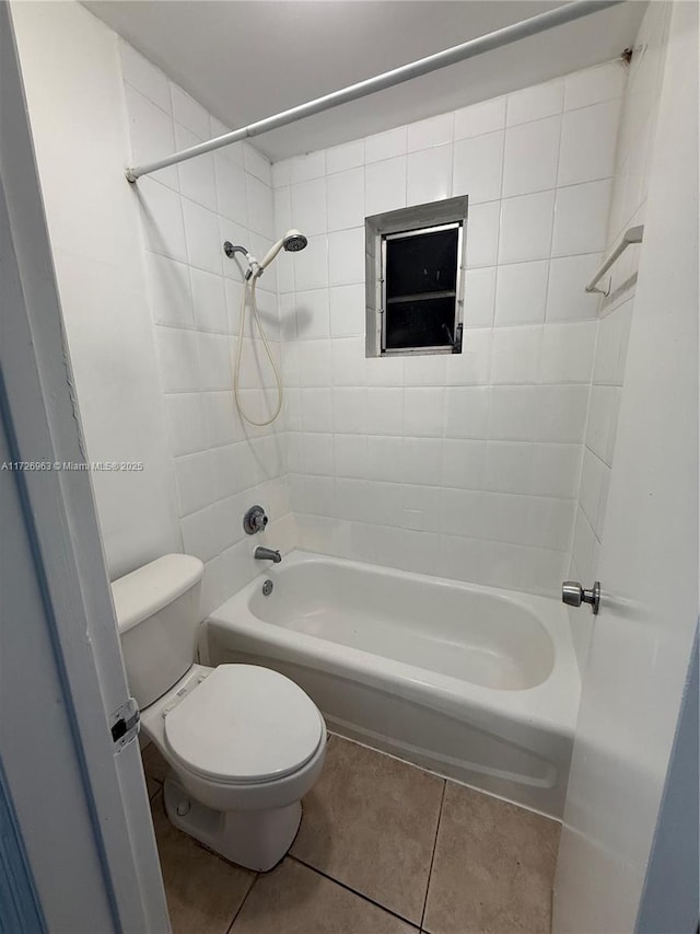 bathroom with toilet, tiled shower / bath, and tile patterned flooring