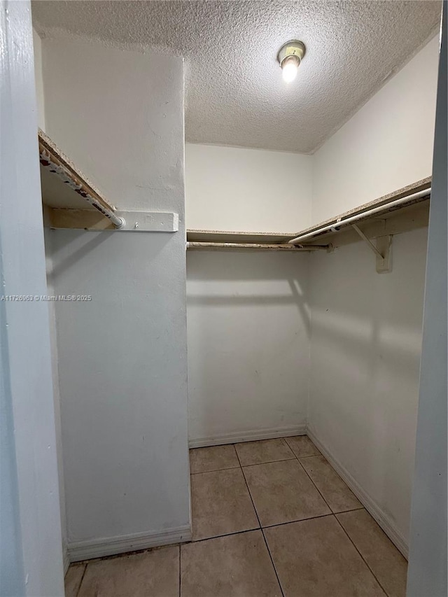 walk in closet with light tile patterned flooring