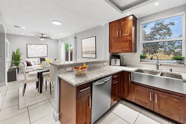 kitchen featuring ceiling fan, light stone counters, stainless steel dishwasher, and kitchen peninsula