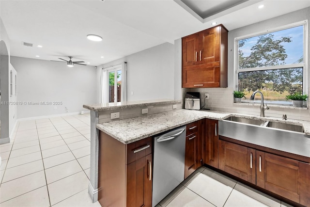 kitchen featuring stainless steel dishwasher, kitchen peninsula, ceiling fan, light stone counters, and light tile patterned floors