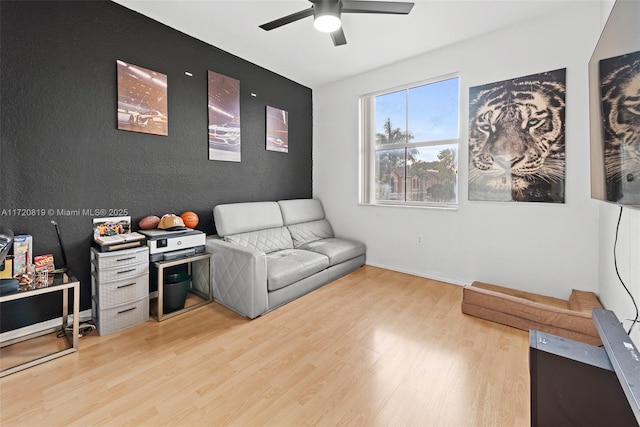 living area with light wood-type flooring and ceiling fan