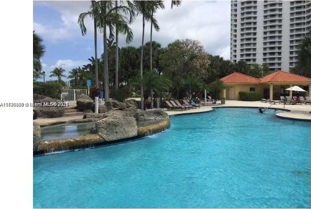 view of pool featuring pool water feature and a patio