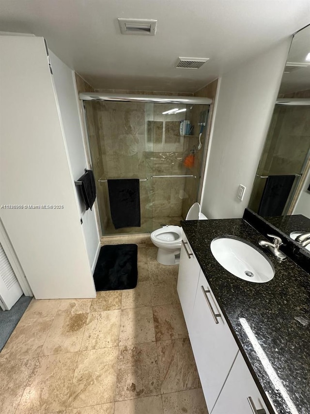 bathroom featuring vanity, toilet, and walk in shower