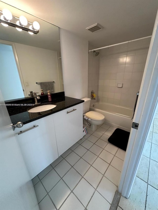 full bathroom featuring toilet, tile patterned flooring, tiled shower / bath combo, and vanity