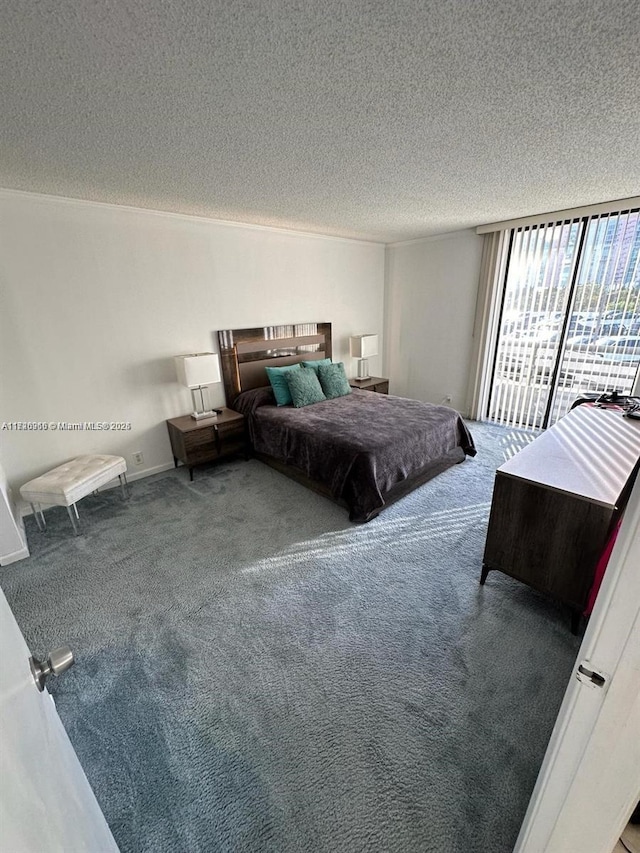 bedroom with access to outside, carpet floors, floor to ceiling windows, and a textured ceiling