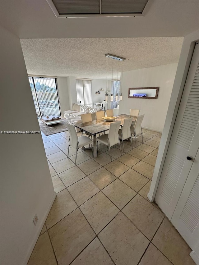 unfurnished dining area with a textured ceiling and light tile patterned floors