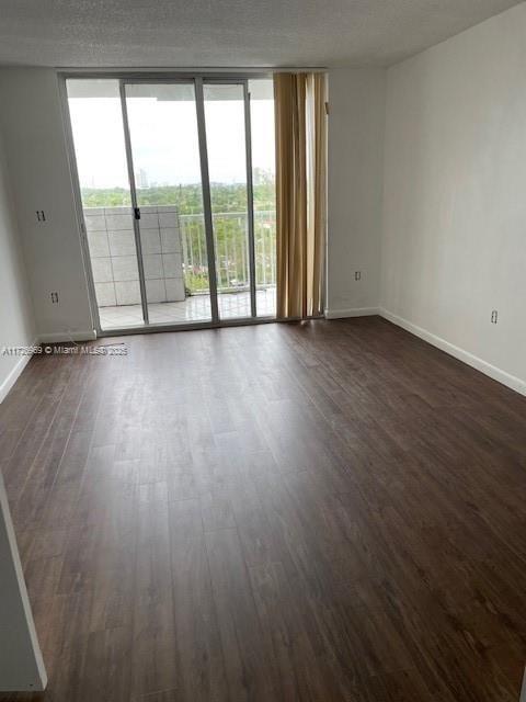 spare room with dark hardwood / wood-style floors and expansive windows