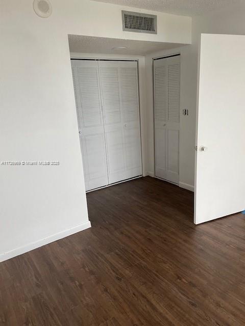 unfurnished bedroom with dark hardwood / wood-style floors