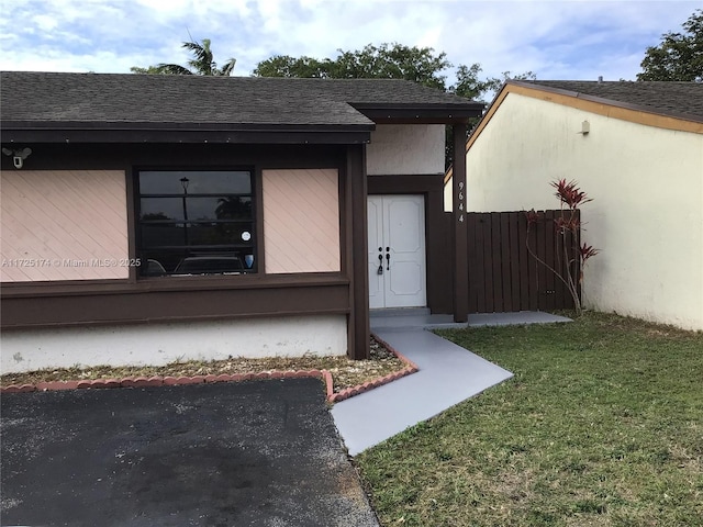 property entrance with a lawn