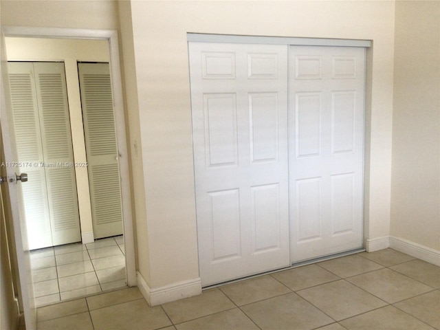 unfurnished bedroom featuring light tile patterned floors and a closet