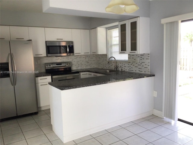 kitchen featuring kitchen peninsula, sink, stainless steel appliances, and white cabinetry