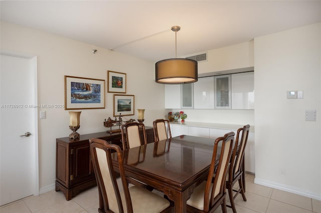 dining space featuring light tile patterned floors, visible vents, and baseboards