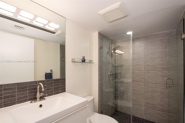 full bath featuring toilet, tasteful backsplash, a stall shower, and visible vents