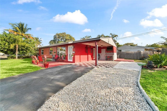 view of front of home featuring a patio, a front yard, and fence