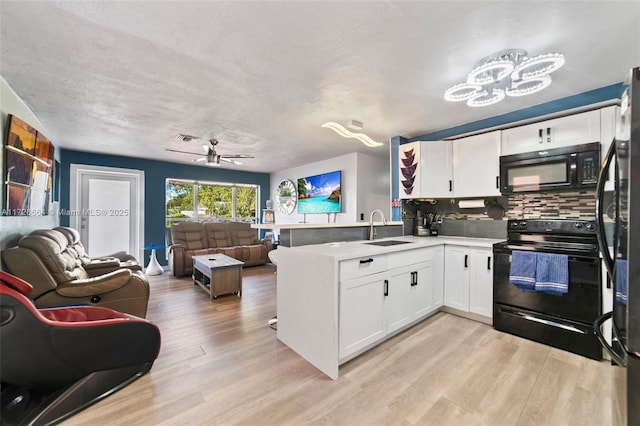 kitchen featuring white cabinetry, kitchen peninsula, sink, and black appliances